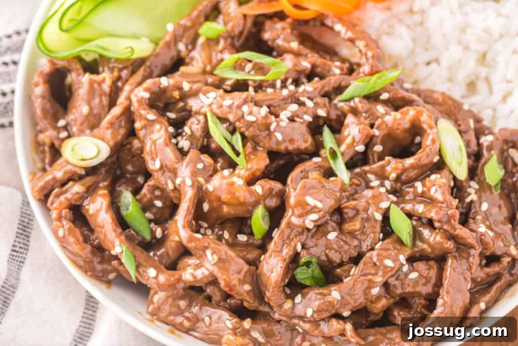 Korean Beef Bulgogi bowl with tender beef strips, white rice, cucumber ribbons, carrots, sesame seeds, and green onions