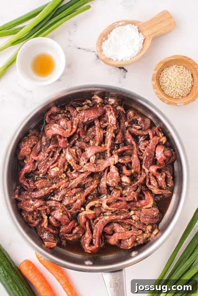 Marinated Korean Beef Bulgogi beef strips in a skillet before cooking with bulgogi sauce