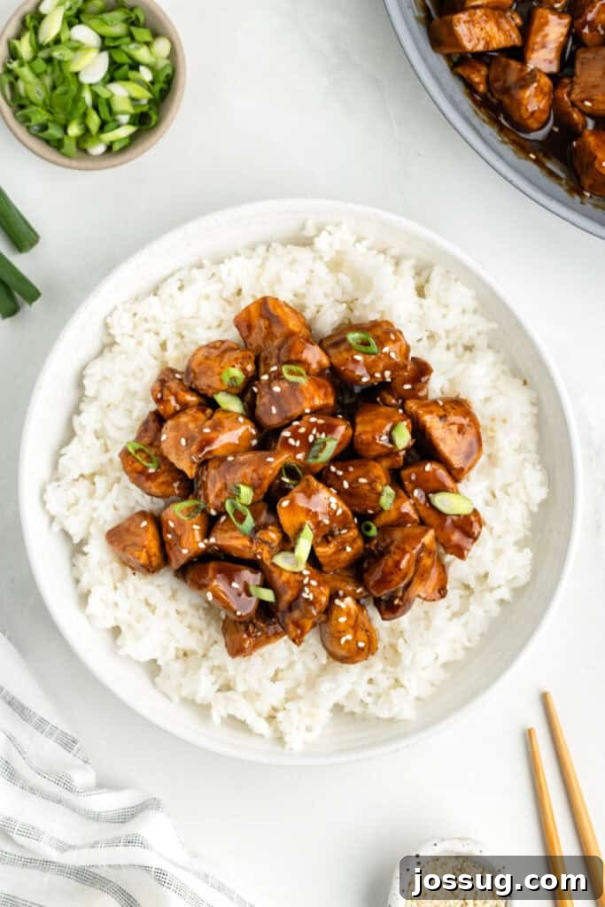 Bowl of Chicken Teriyaki served over white rice with green onions and sesame seeds