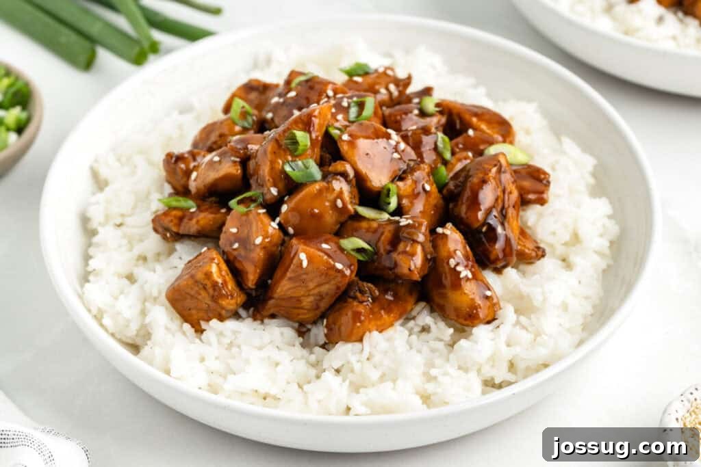 Close-up of Chicken Teriyaki over white rice with sesame seeds and green onions