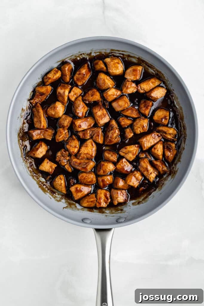 Chicken Teriyaki cooking in a skillet with thick glossy homemade teriyaki sauce