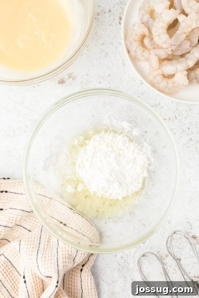 Crispy Honey Walnut Shrimp Recipe: Restaurant-Style at Home 12 Egg whites and cornstarch in a bowl for crispy Honey Walnut Shrimp batter