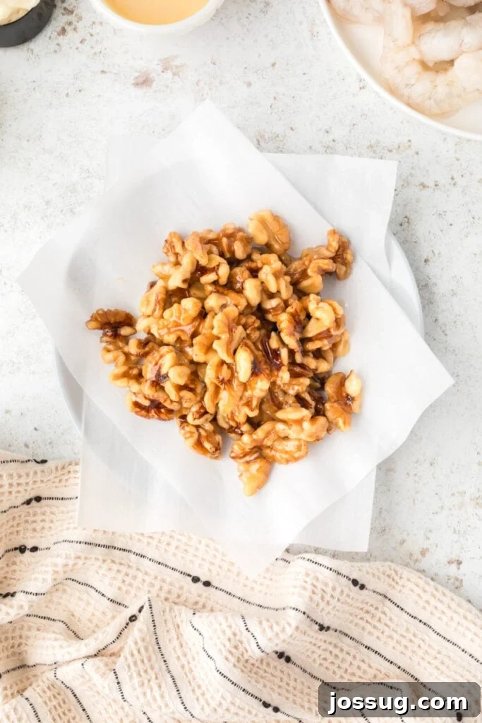Crispy Honey Walnut Shrimp Recipe: Restaurant-Style at Home 9 Homemade candied walnuts cooling on parchment paper for Honey Walnut Shrimp
