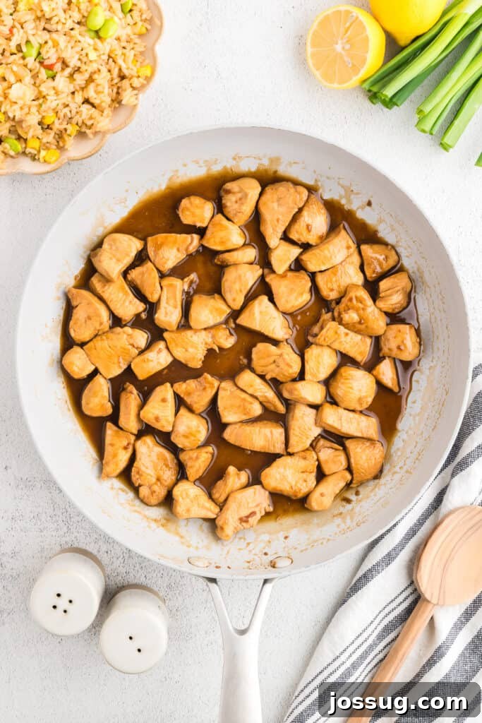 Homemade Hibachi Chicken: Restaurant-Style Recipe You’ll Love 12 Finished Hibachi Chicken in buttery hibachi sauce served in a skillet with fried rice for an easy weeknight dinner.