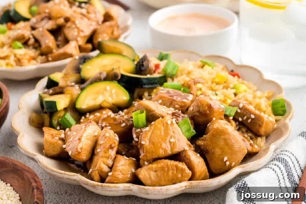 Homemade Hibachi Chicken: Restaurant-Style Recipe You’ll Love 4 Plate of homemade Hibachi Chicken served with fried rice, zucchini, mushrooms, yum yum sauce, and sesame seeds for a takeout-style meal at home.