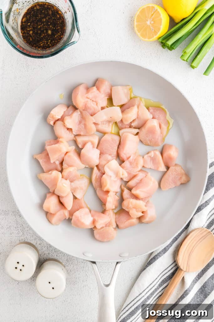 Homemade Hibachi Chicken: Restaurant-Style Recipe You’ll Love 6 Raw chicken breast pieces cooking in a skillet for an easy Hibachi Chicken recipe with homemade hibachi sauce ingredients nearby.