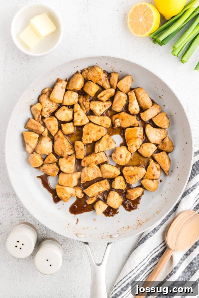 Homemade Hibachi Chicken: Restaurant-Style Recipe You’ll Love 10 Hibachi Chicken simmering in a buttery soy garlic sauce in a skillet with fried rice served nearby.