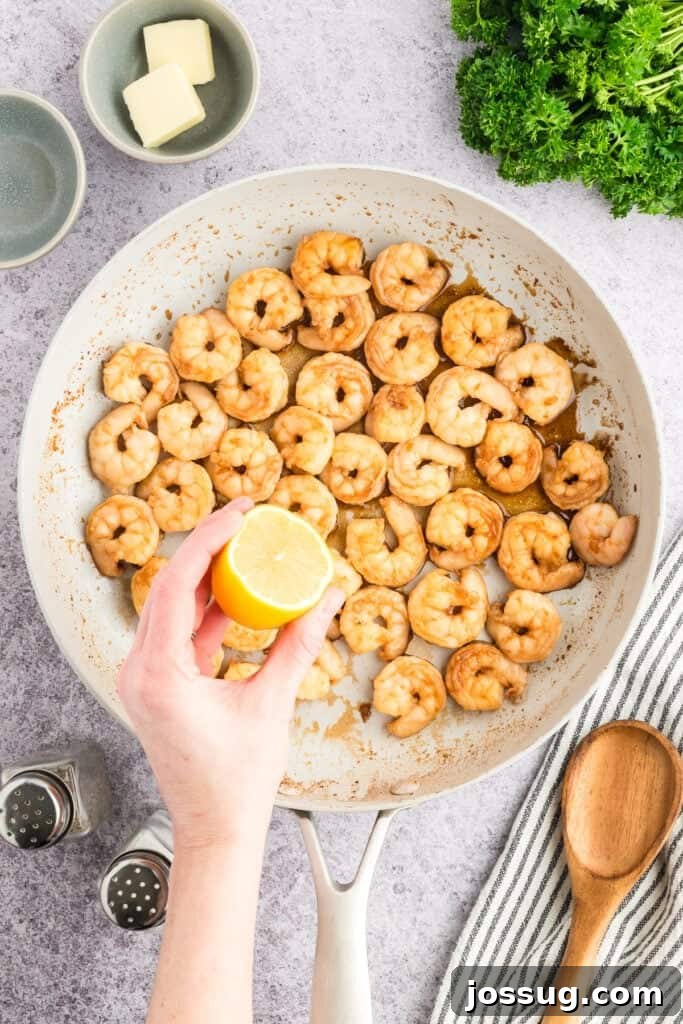 Copycat Hibachi Shrimp Recipe: Restaurant-Style at Home 11 Fresh lemon juice being squeezed over cooked Hibachi Shrimp in a skillet.