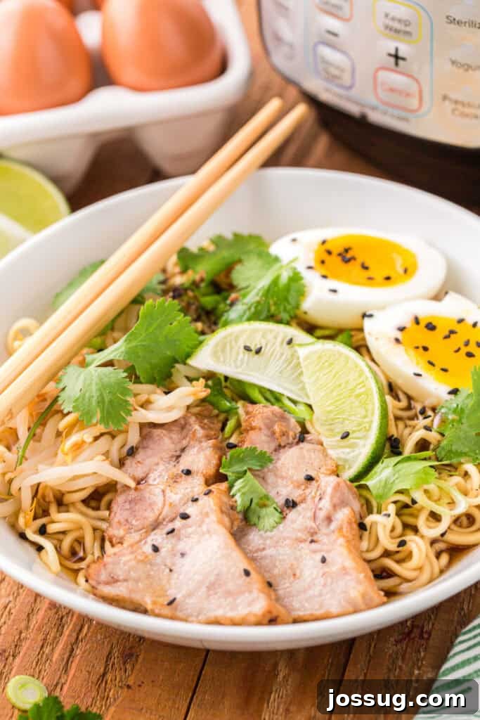 Instant Pot Pork Ramen Recipe: Homemade Broth in 30 Minutes 2 Close-up of Instant Pot Ramen with sliced pork, soft-boiled eggs, bean sprouts, cilantro, lime wedges, black sesame seeds, and chopsticks