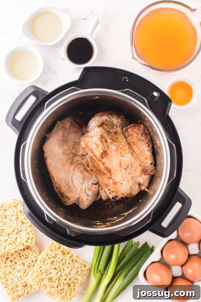 Instant Pot Pork Ramen Recipe: Homemade Broth in 30 Minutes 6 Browned pork shoulder in an Instant Pot surrounded by ramen noodles, eggs, green onions, and broth ingredients