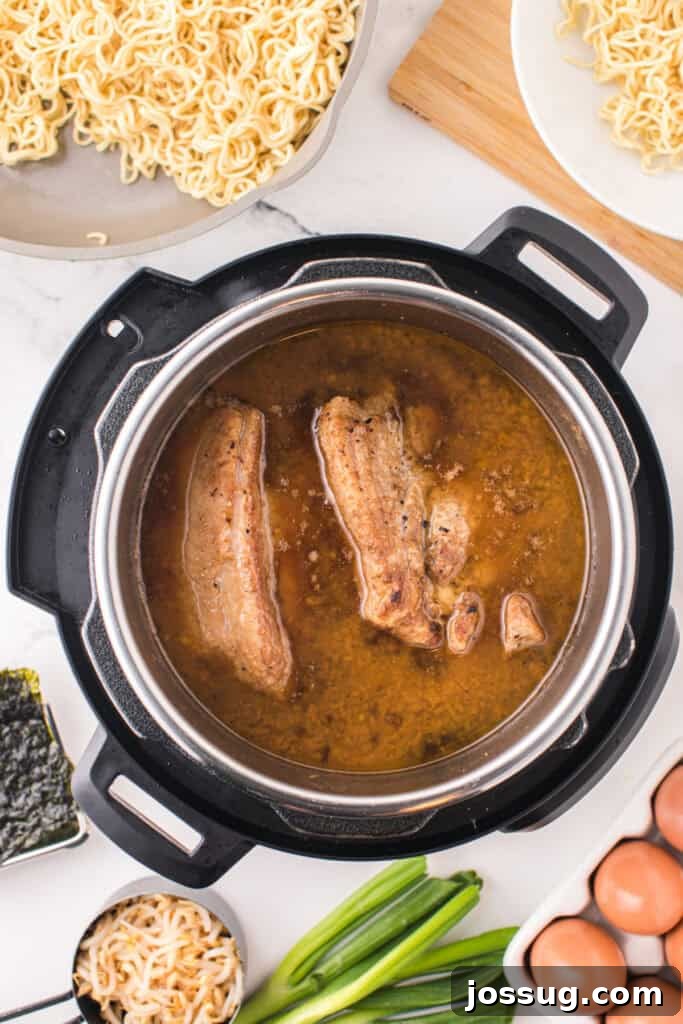 Instant Pot Pork Ramen Recipe: Homemade Broth in 30 Minutes 9 Cooked pork shoulder in broth inside an Instant Pot with ramen noodles, eggs, bean sprouts, nori, and green onions surrounding the pot