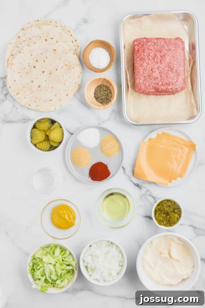 Smash Burger Tacos: Viral Cheeseburger-Style Taco Recipe 3 Ingredients for Smash Burger Tacos arranged on a marble surface, including flour tortillas, ground beef, American cheese, lettuce, onion, pickles, mayonnaise, relish, mustard, oil, and seasonings.