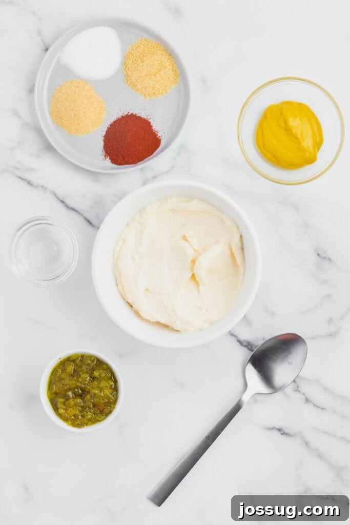 Smash Burger Tacos: Viral Cheeseburger-Style Taco Recipe 5 Bowl of mayonnaise with pickle relish, mustard, seasonings, vinegar, and a spoon arranged nearby for making burger sauce.
