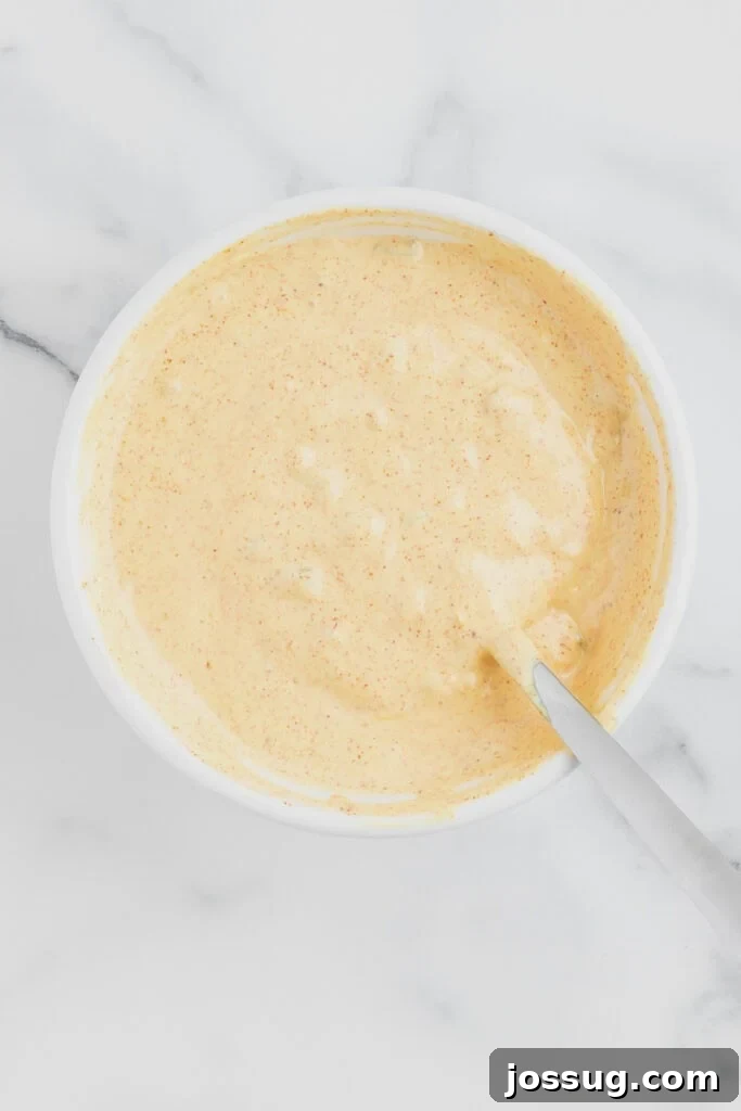 Smash Burger Tacos: Viral Cheeseburger-Style Taco Recipe 7 Homemade burger sauce mixed together in a white bowl with a spoon resting inside.