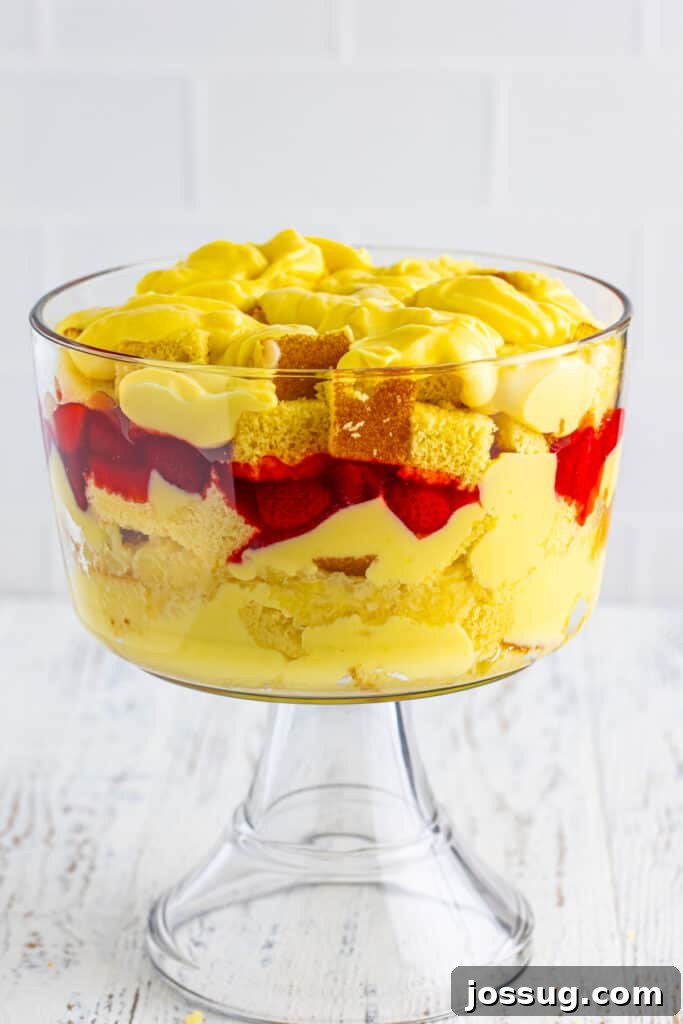 Decadent Banana Split Trifle Recipe with Layers of Cream and Fruit 14 Vanilla pudding spread over the top layer of cake cubes in a clear trifle bowl for Banana Split Trifle.