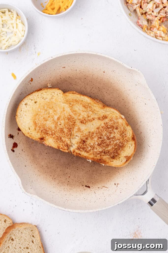Cheesy Crab Melt: Seafood Grilled Cheese Sandwich Recipe 12 Cheesy Crab Melt sandwich cooking in a skillet until golden brown