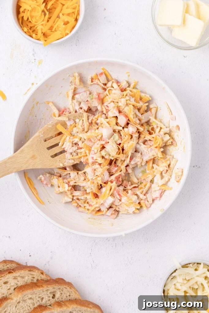 Cheesy Crab Melt: Seafood Grilled Cheese Sandwich Recipe 6 Cheesy crab filling mixed together in a bowl with shredded cheese, imitation crab, mayonnaise, and seasonings