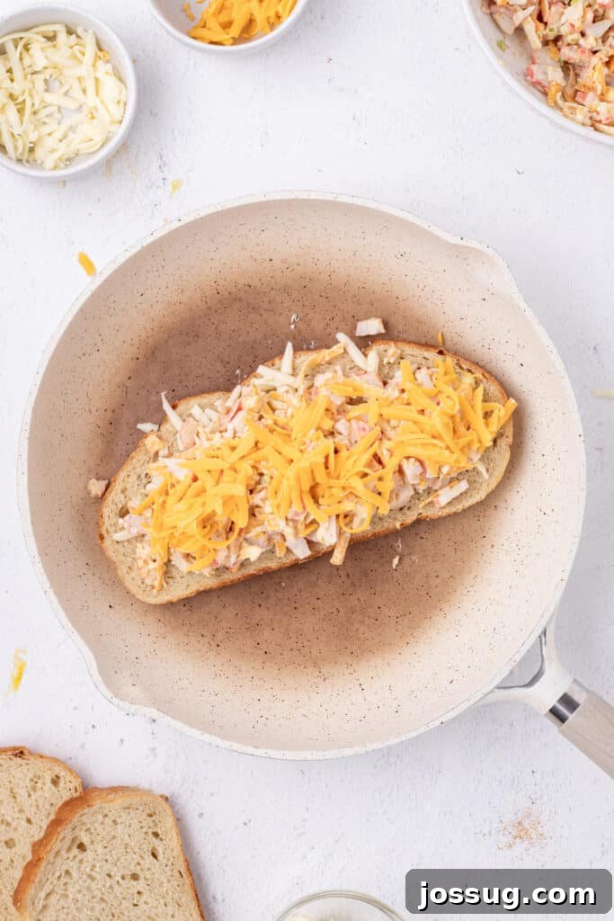 Cheesy Crab Melt: Seafood Grilled Cheese Sandwich Recipe 10 Shredded Cheddar cheese added on top of the crab filling in a skillet