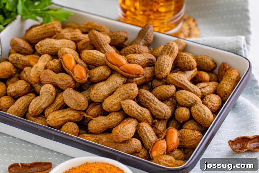Serving dish filled with homemade Creole Boiled Peanuts, with a few peanuts opened to show the cooked peanuts inside.