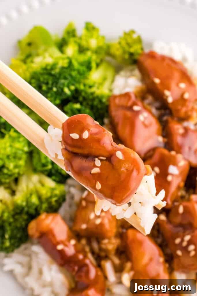 Mongolian Pork Stir-Fry: Restaurant Flavor at Home 8 Chopsticks holding a bite of Mongolian Pork with rice and broccoli