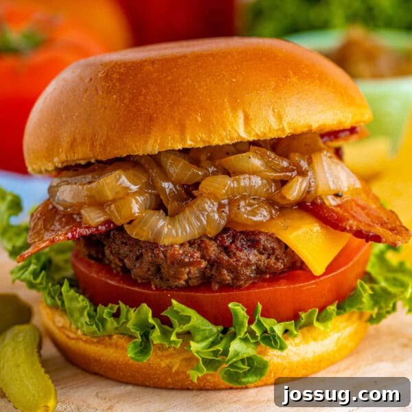 closeup of an assembled bacon cheeseburger with caramelized onions