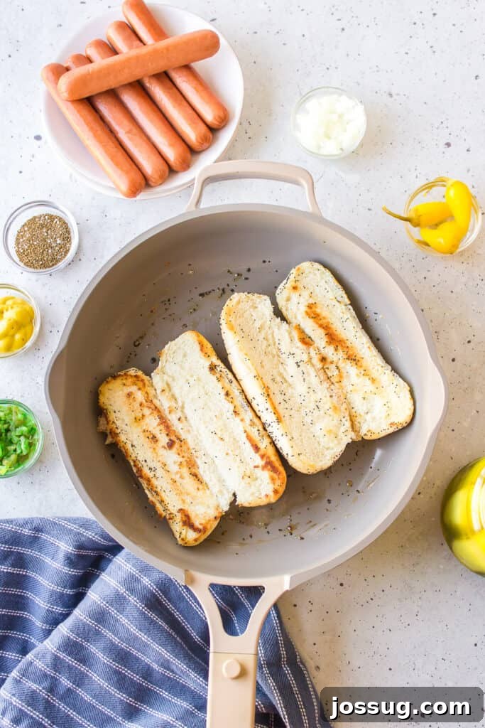 Toasting poppy seed hot dog buns in butter for homemade Chicago Hot Dogs