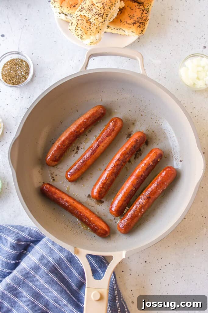 All-beef hot dogs browning in a skillet for Chicago Dogs