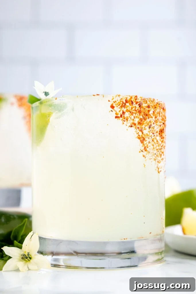 Jalapeño Margarita: Spicy Lime Cocktail Recipe 10 Close-up side view of a homemade jalapeño margarita with a Tajín rim and fresh lime garnish