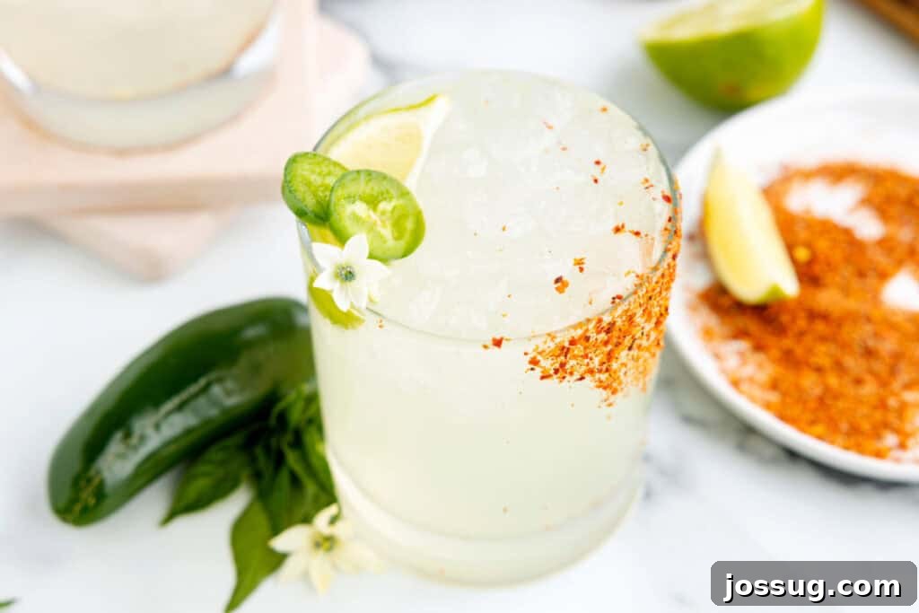 Jalapeño Margarita: Spicy Lime Cocktail Recipe 4 Homemade spicy margarita with fresh jalapeño slices, lime wedge, and a Tajín rim ready to serve
