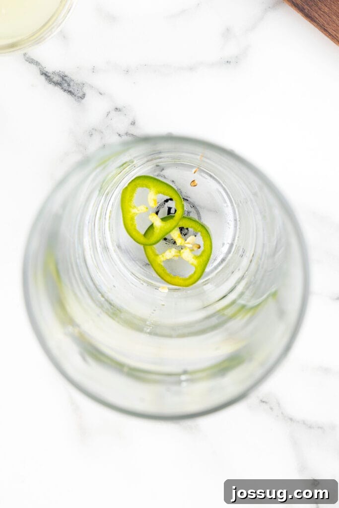 Jalapeño Margarita: Spicy Lime Cocktail Recipe 5 Fresh jalapeño slices in the bottom of a cocktail shaker before muddling