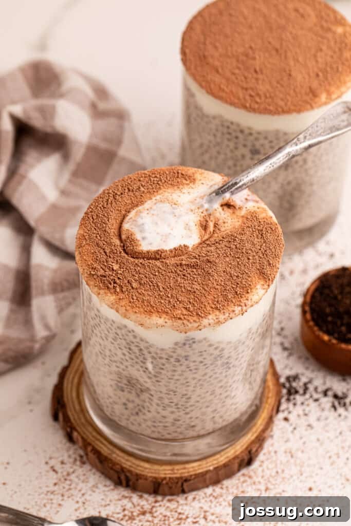 Tiramisu Chia Pudding Recipe: Coffee Cream Breakfast or Dessert 6 Spoon scooping creamy Tiramisu Chia Pudding from a glass topped with cocoa powder
