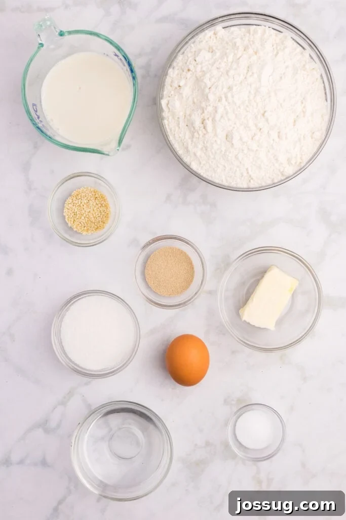 How to Make Soft Homemade Hamburger Buns 3 Ingredients needed to make homemade hamburger buns arranged on a marble countertop
