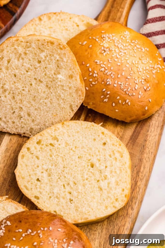 How to Make Soft Homemade Hamburger Buns 9 Homemade hamburger buns on a wooden serving board ready for burgers