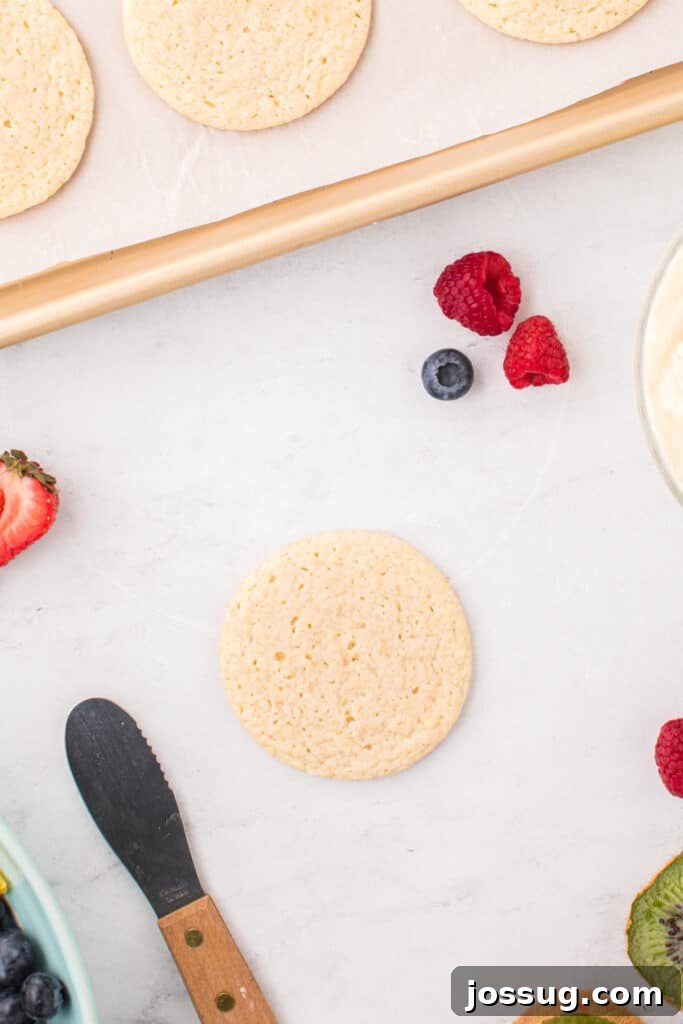 Fruit Pizza Cookies: Sugar Cookie Dessert with Fresh Fruit 12 Baked sugar cookies cooling before decorating with frosting and fresh fruit.