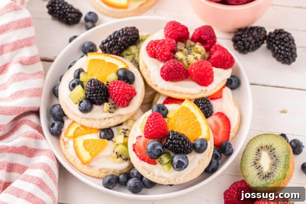 Fruit Pizza Cookies: Sugar Cookie Dessert with Fresh Fruit 4 Platter of homemade Fruit Pizza Cookies topped with cream cheese frosting, fresh berries, kiwi, and orange slices.