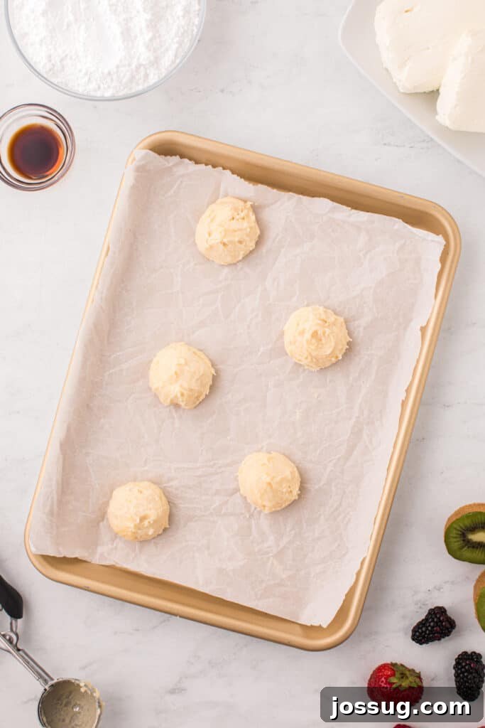 Fruit Pizza Cookies: Sugar Cookie Dessert with Fresh Fruit 8 Scoops of Fruit Pizza Cookie dough portioned onto a parchment-lined baking sheet.