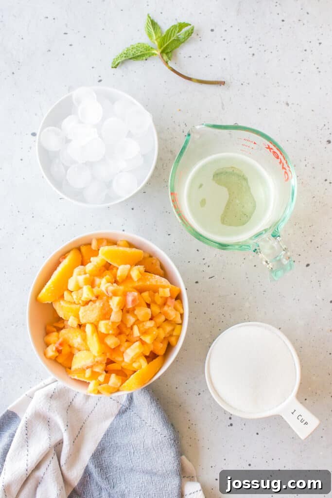 Frozen Peach Bellini Cocktail Recipe for Summer 3 Ingredients for a Frozen Peach Bellini including frozen peaches, granulated sugar, ice, Prosecco, lemon juice, and fresh mint.