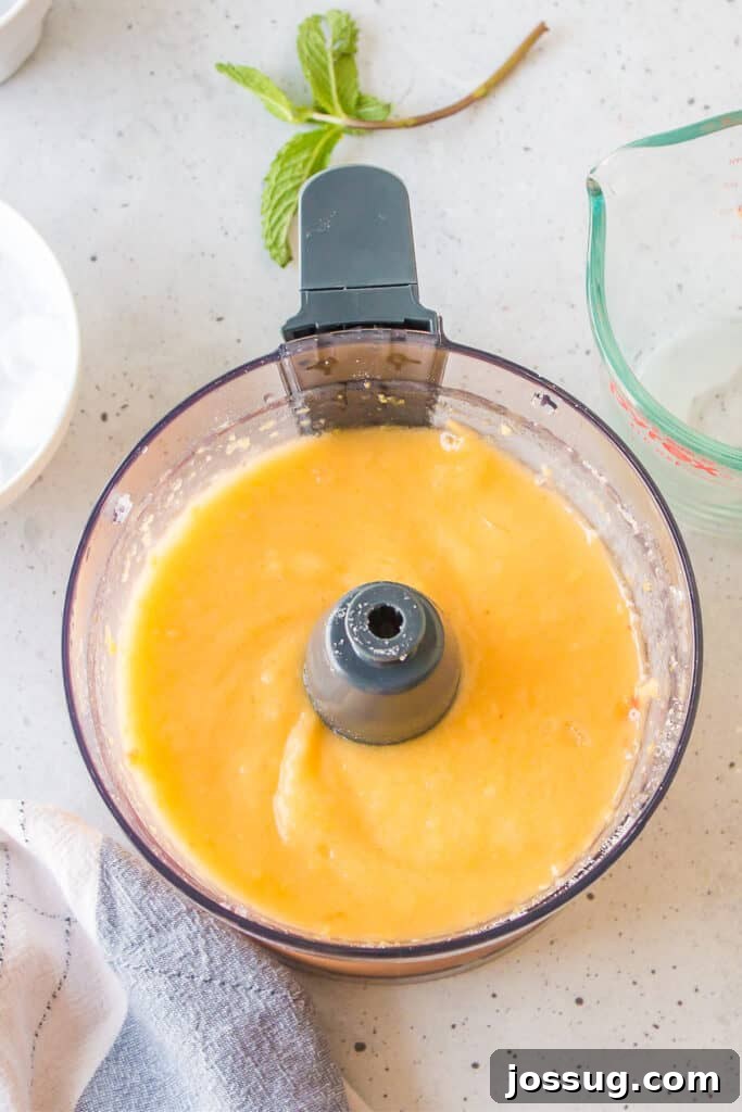 Frozen Peach Bellini Cocktail Recipe for Summer 7 Peach mixture blended until smooth for an easy frozen peach cocktail recipe.