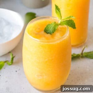 Frozen Peach Bellini Cocktail Recipe for Summer 10 Square image of a Frozen Peach Bellini garnished with mint, perfect for recipe cards and social media.