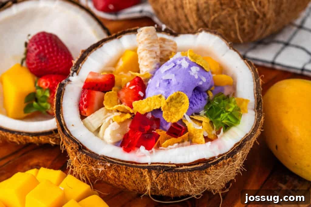 Halo-Halo: Authentic Filipino Shaved Ice Recipe 4 Close-up of homemade Halo Halo featuring ube ice cream, mango, strawberries, gelatin cubes, banana, corn flakes, and wafer cookies.