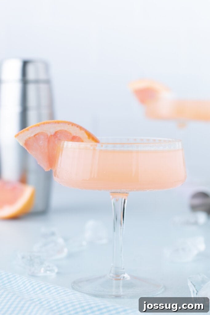 Fresh grapefruit Paloma Cocktail served in a coupe glass with grapefruit garnish.