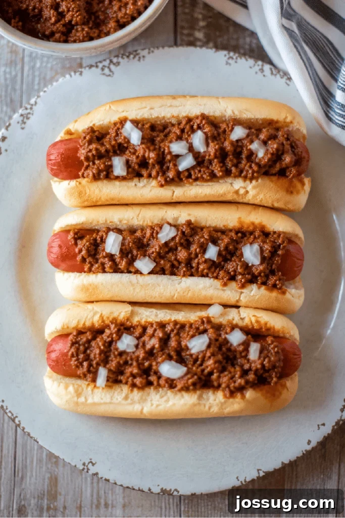 Slow Cooker Hot Dog Chili with Homemade Chili Sauce 2 Three homemade chili dogs topped with Slow Cooker Hot Dog Chili and diced onions.