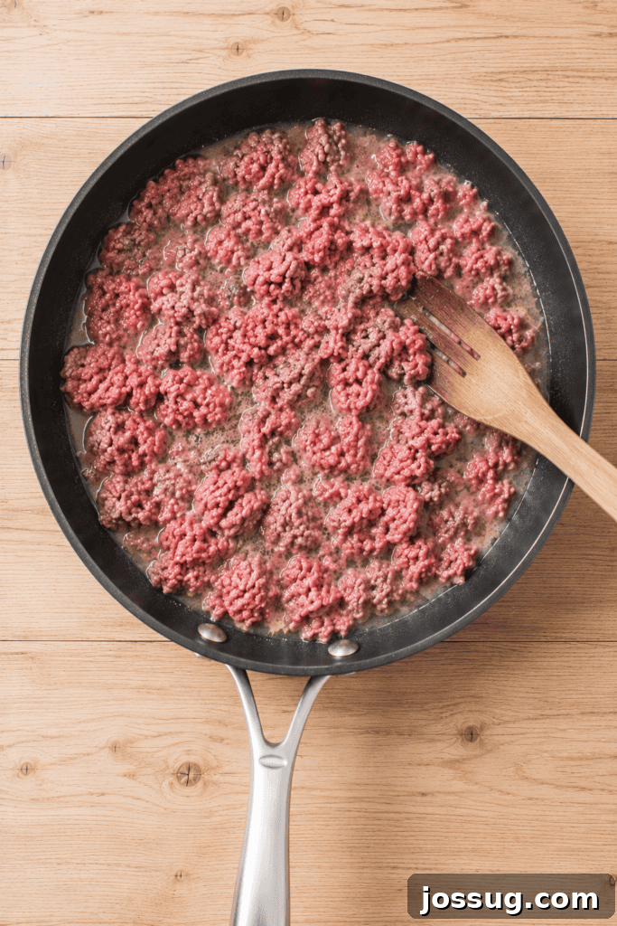 Slow Cooker Hot Dog Chili with Homemade Chili Sauce 5 Ground beef cooking with water in a skillet for homemade hot dog chili.