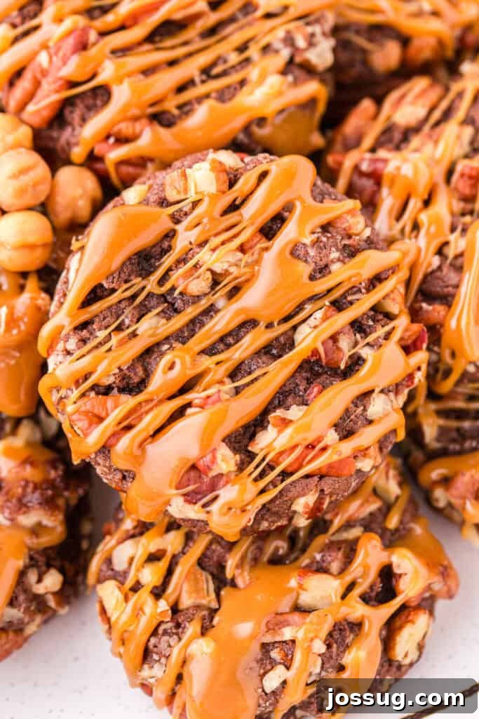 Close-up of Easy Turtle Cookies topped with chopped pecans and a generous caramel drizzle.