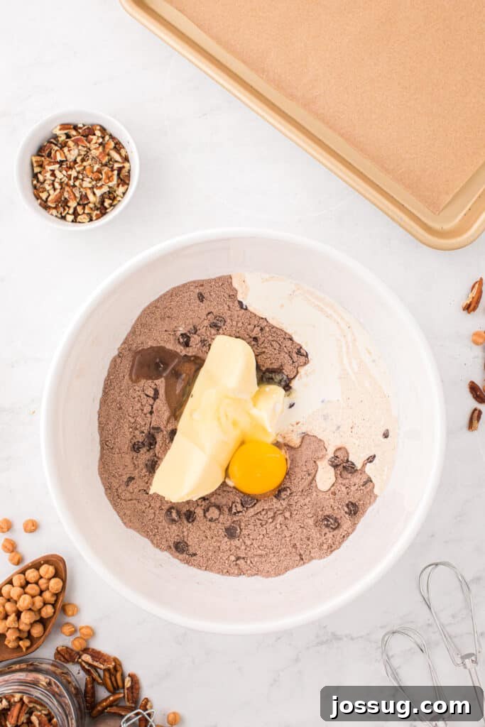 Butter, egg, and heavy cream added to the chocolate cookie mixture for Easy Turtle Cookies.