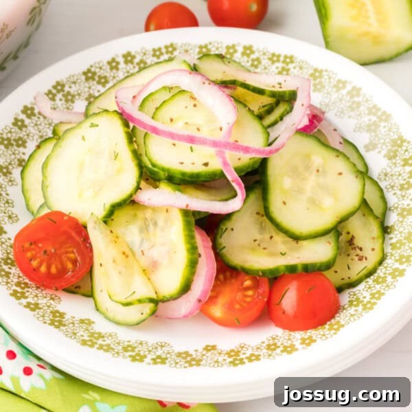 Close-up square image of cucumber tomato salad on a plate with onions and tomatoes