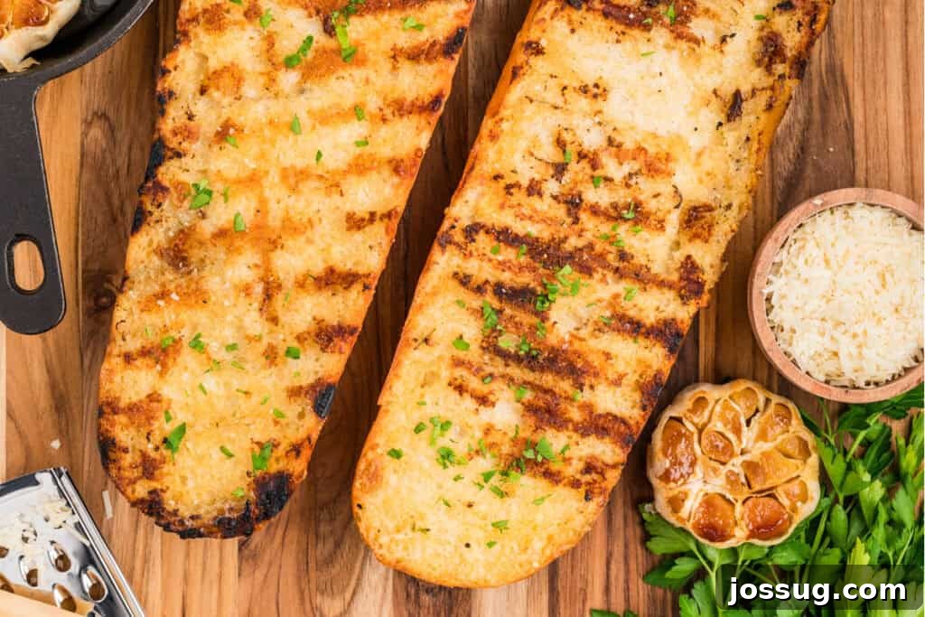 Overhead view of Grilled Garlic Bread with roasted garlic, Parmesan cheese, and fresh parsley on a wooden board.