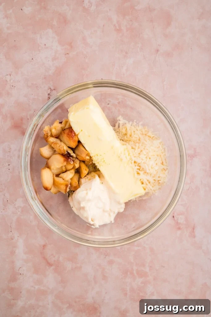 Butter, roasted garlic, mayonnaise, Parmesan cheese, and garlic salt in a bowl before mixing for Grilled Garlic Bread.