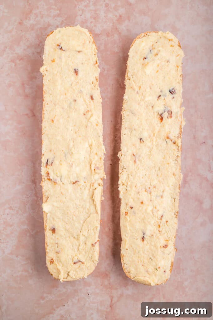 French bread halves evenly spread with roasted garlic butter before grilling.