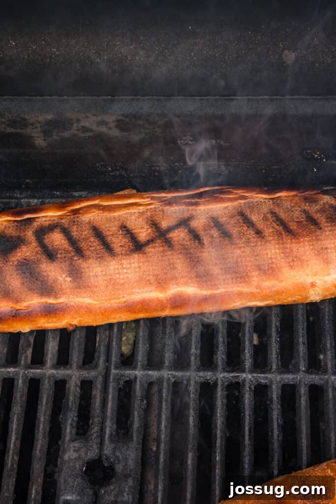 Grilled Garlic Bread cooking over direct heat with the bread flipped to create grill marks.